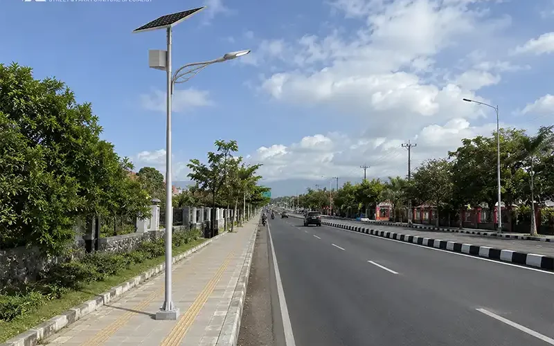 Tiang lampu jalan tenaga surya terpasang di sisi jalan dengan panel surya dan lampu LED 