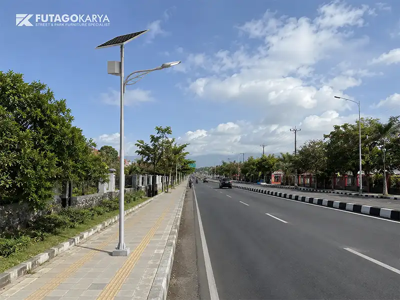 Tiang lampu jalan tenaga surya terpasang di sisi jalan dengan panel surya dan lampu LED 